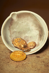 Nuggets of illegaly melted stolen gold pieces in ceramic bowl