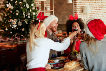 Friends having dinner for Christmas eve at home. Christmas holidays concept.