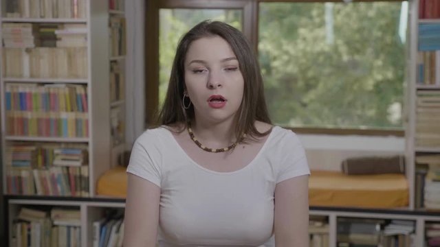Teenage woman expressing disbelief and shock with amazed face and opened mouth covering face with hands