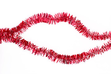 Lip shaped red tinsel on a white background. Red Christmas decoration garland in a shape of lips, isolated on white background.
