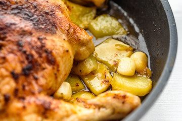 chicken baked with potatoes close up