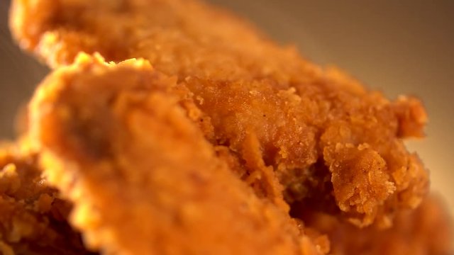 Rotation Bucket full of crispy kentucky fried chicken with smoke on brown background.