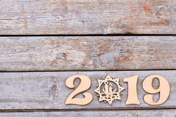 Number 2019 from wood and snowflake. On old rustic wooden background numbered 2019 from wood and wooden figure snowflake, copy space. New Year 2019 concept.