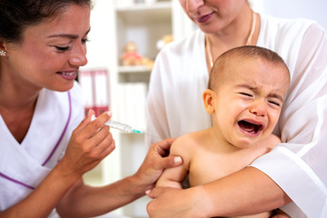 Obraz na płótnie Canvas Baby having a theatrical objection to a vaccine