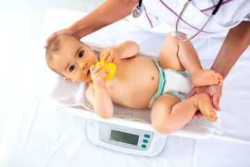 A pediatrician doing weight measurement
