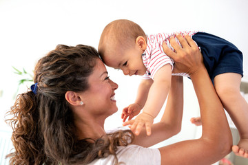 Beautiful young mother playing and having smiling time with her baby