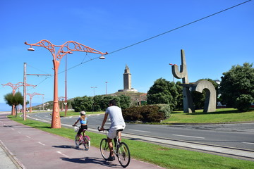 Man and girl cycling on a promenade. Torre de Hercules public park, La Coruña, Spain. © JB