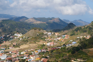 Fototapeta na wymiar aerial view on small village / town in green mountain landscape