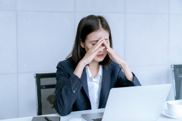 Asian business woman headache stressed because of work mistake problems about profit losses to be...