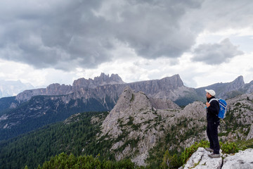 Fototapeta na wymiar Man admires the mountain landscape of the Alpine peaks. Dolomites