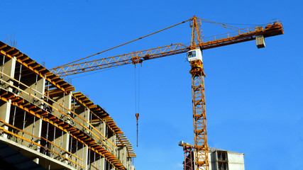 Fototapeta na wymiar Construction site with crane and building. Crane and building under construction.