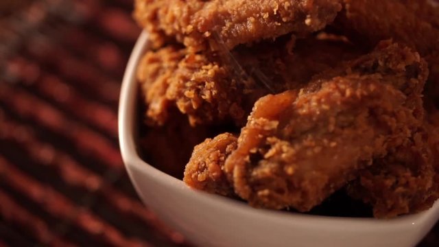 Rotation Bucket full of crispy kentucky fried chicken with smoke on brown background.