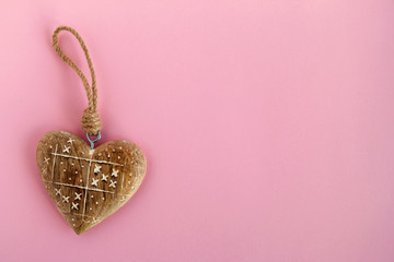 Top view on a Christmas and New Year decorations on a pink background, top view. Wooden heart with white pattern.