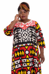 Fototapeta premium Studio shot of fat black African woman standing while talking on