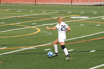 Blond girl runs with the ball