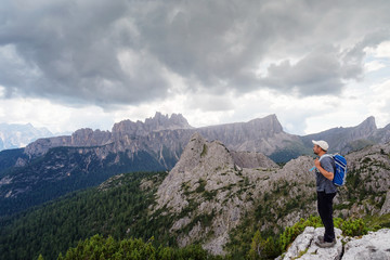 Fototapeta na wymiar Man admires the mountain landscape of the Alpine peaks. Dolomites