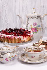 Sweet cake with cherry jelly, tasty and fresh. Antique tea set