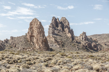 Fototapeta premium Group of large lava rocks in the middle of a desert landscape, on a sunny day