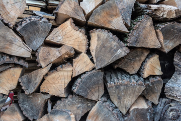 Fototapeta premium Firewood in woodpile, prepared for Winter. Pile of firewood. The firewood background. A stack of neatly stacked, dry firewood outdoors.