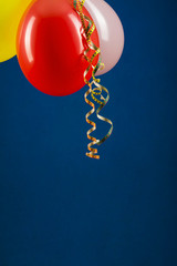 Colorful balloons with serpentine on a blue background