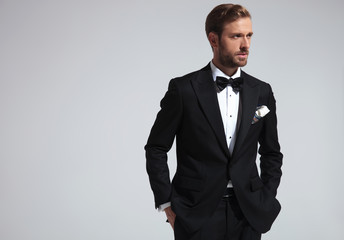 serious  man wearing tuxedo and standing with hands in pockets