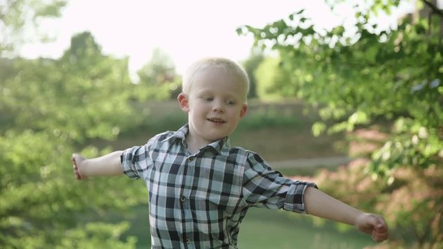 Portrait of cute little happy boy in a summer park Slow motion Full HD