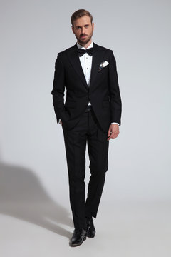 young elegant groom stepping forward with hand in pocket
