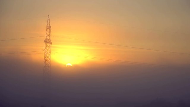 Silhouette of high voltage pole and many cables, electric lines with blurred sunrise sky background on technology development concept. 4k video