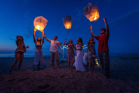 Group Of Friends Lighting Lanterns