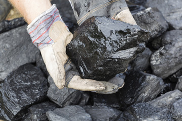 A man holding a piece of coal.