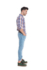 side view of man with hands in pockets looking down
