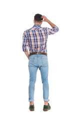 Fototapeta premium rear view of confused casual man holding his head