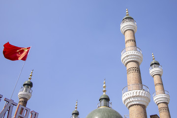 Fototapeta na wymiar Chinese flag next to minarets of mosque, Urumchi, Xinjiang, China