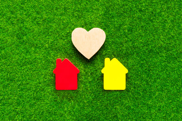 two houses, a heart on the background of artificial green grass. real estate, inheritance, family law, insurance.