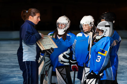 Female coach explaining game plan to hockey team