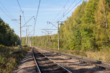 Fototapeta na wymiar Double-track electrified railway on a sunny autumn day