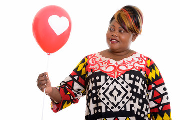 Studio shot of happy fat black African woman smiling while holdi