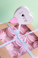 Delicious pink wedding marshmallows with hearts.gift box on white , soft green, pastel background. Valentine day, happy birthday, wedding gift.Eight meringue in box.Candy bar