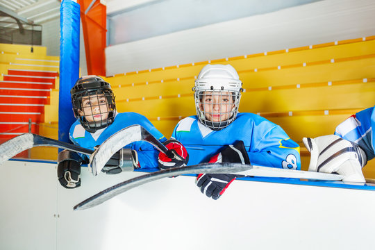 Young hockey players sitting on bench at stadium
