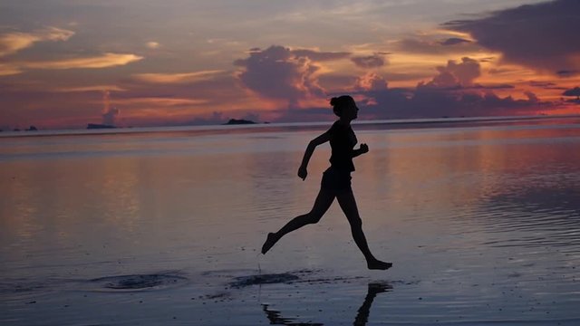 Evening run on the water, the girl athlete on the sea and the magnificent sunset. slow motion, 1920x1080, full hd