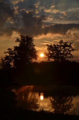 Sonnenaufgang am Weiher, mit Spiegelung im Wasser