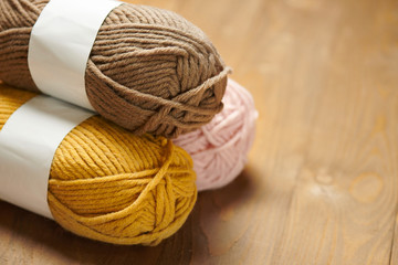 colorful wool threads for knitting on wooden background