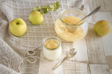 Selbst gekochter Apfelmus in einem Glas mit einem Glas Apfelmus auf Naturjoghurt