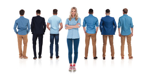 casual female leader stands behind her team of men