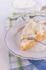Ein Stück selbstgebackener Apfel Steuselkuchen mit Schlagsahne auf einem Teller mit einer Gabel