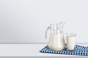 Glass of milk and bottle on desk