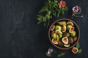 Raw figs served in the bowl on the dark background with blank space,selective focus