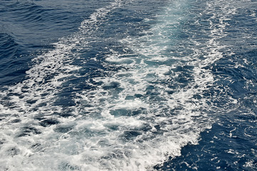 Foamy track of ship on blue sea