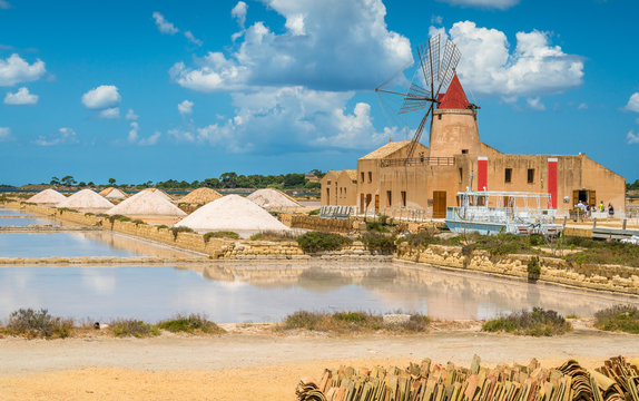 Old pier and windmill at the natural reserve of the "Saline dello Stagnone" near Marsala and Trapani, Sicily.