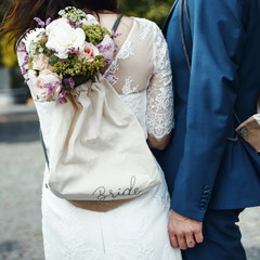 young wedding couple holding hands, groom and bride